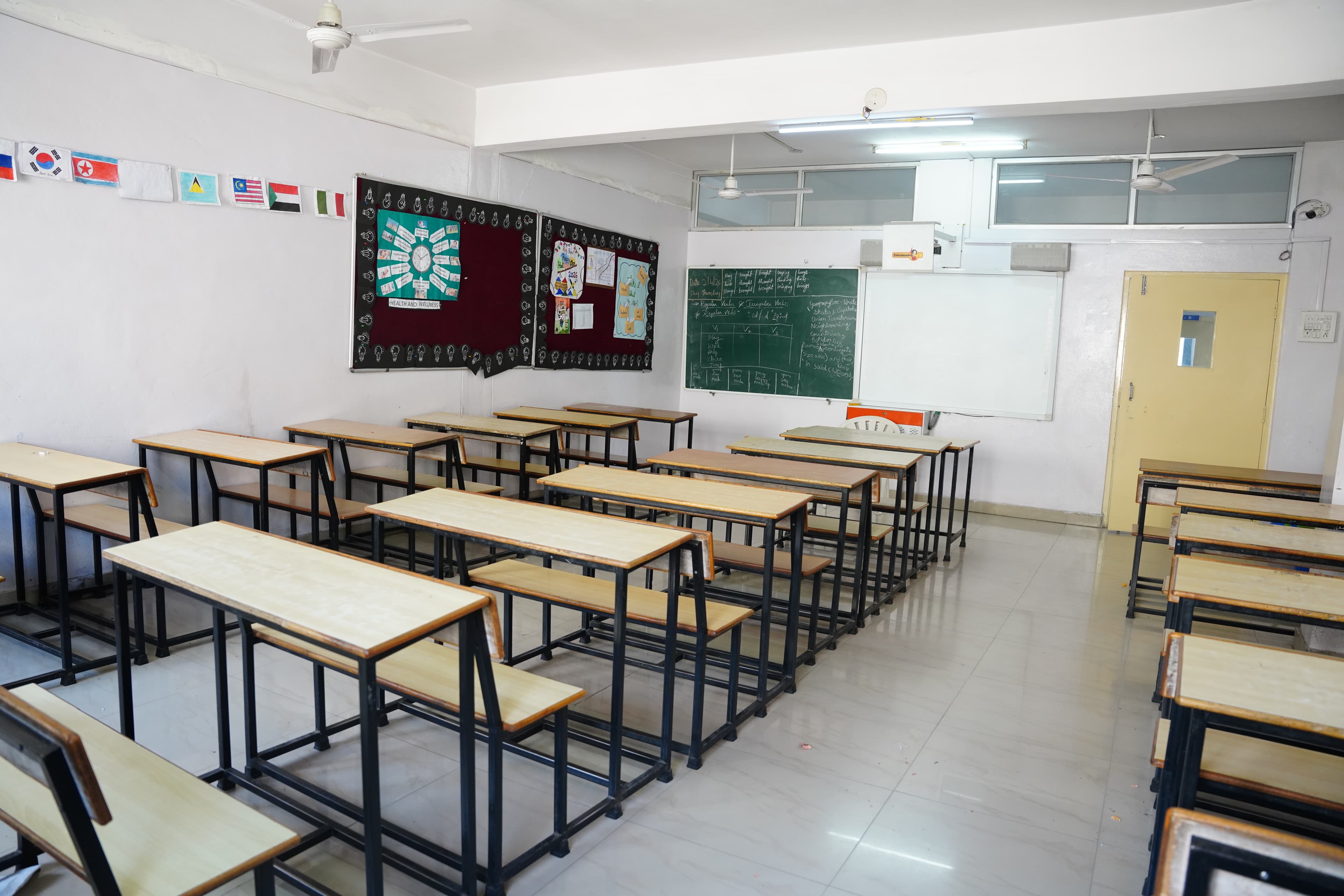 Classroom with desks, chalkboard and international flags
