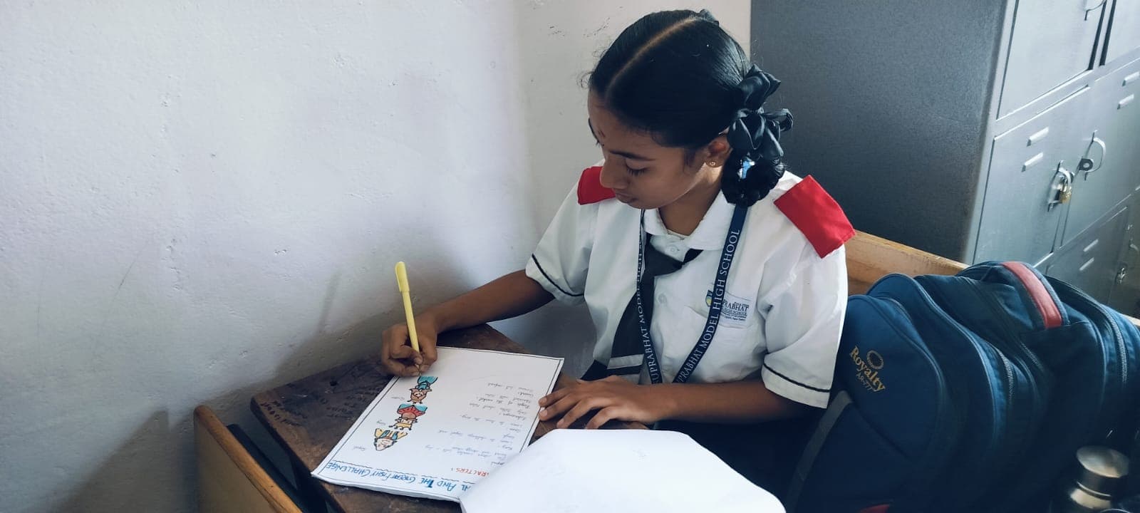 Student writing in notebook during class