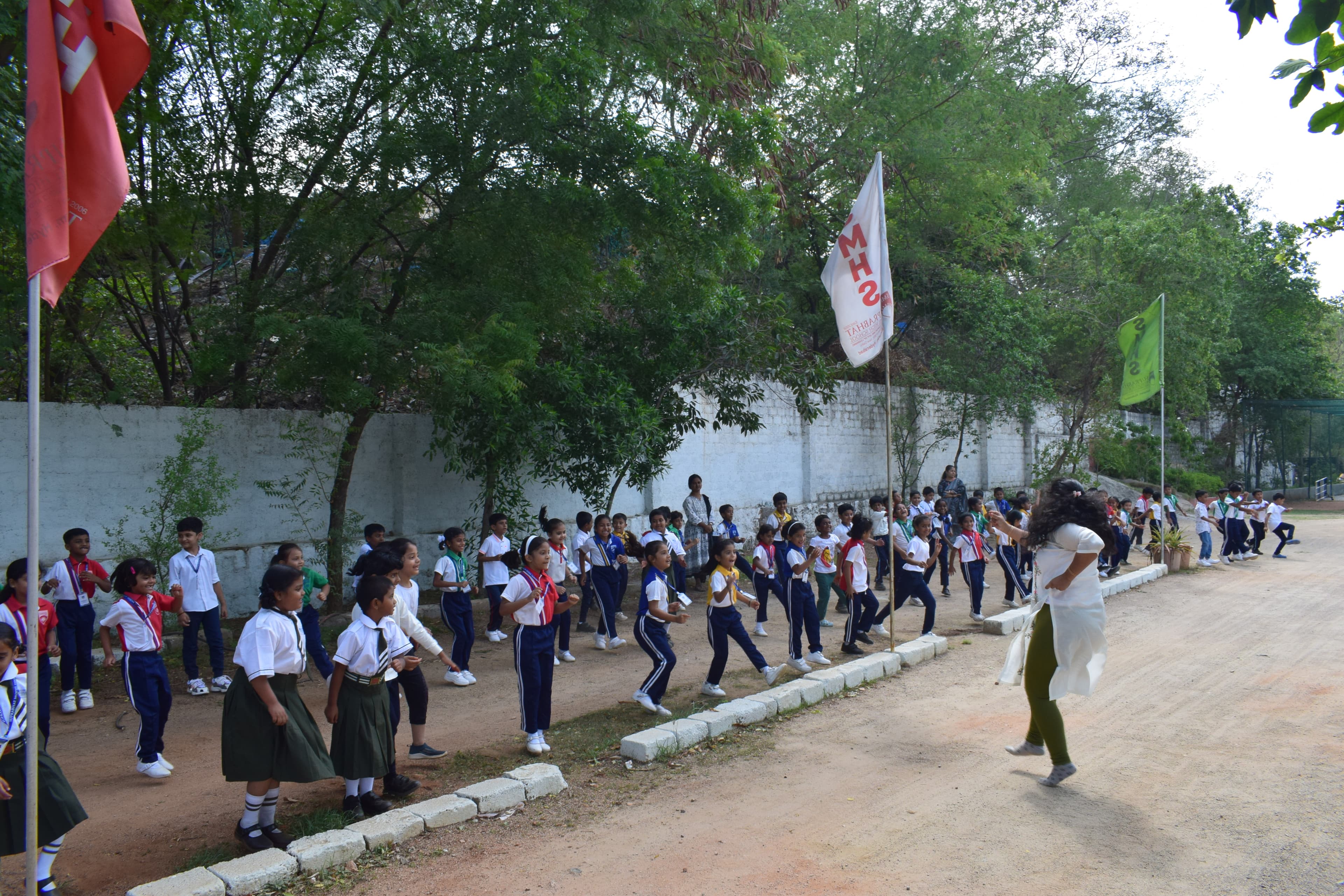 Students in outdoor group exercise with house colours on campus grounds